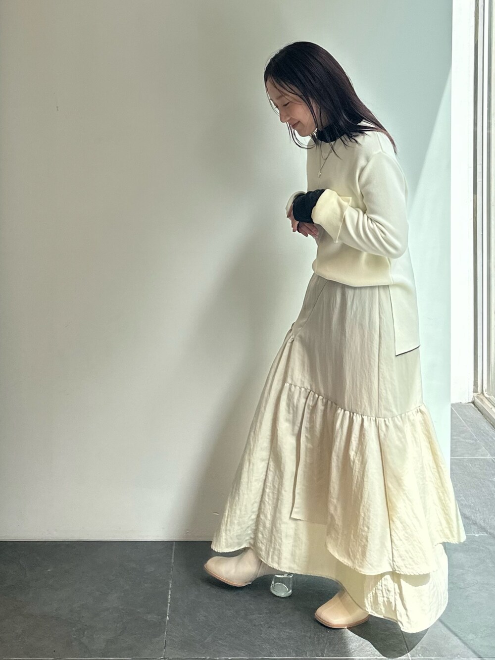 ブラック系のTシャツ/カットソー、ベージュ系のニット/セーター、ベージュ系のスカートを着用したレディースの秋コーディネートの4枚目の写真