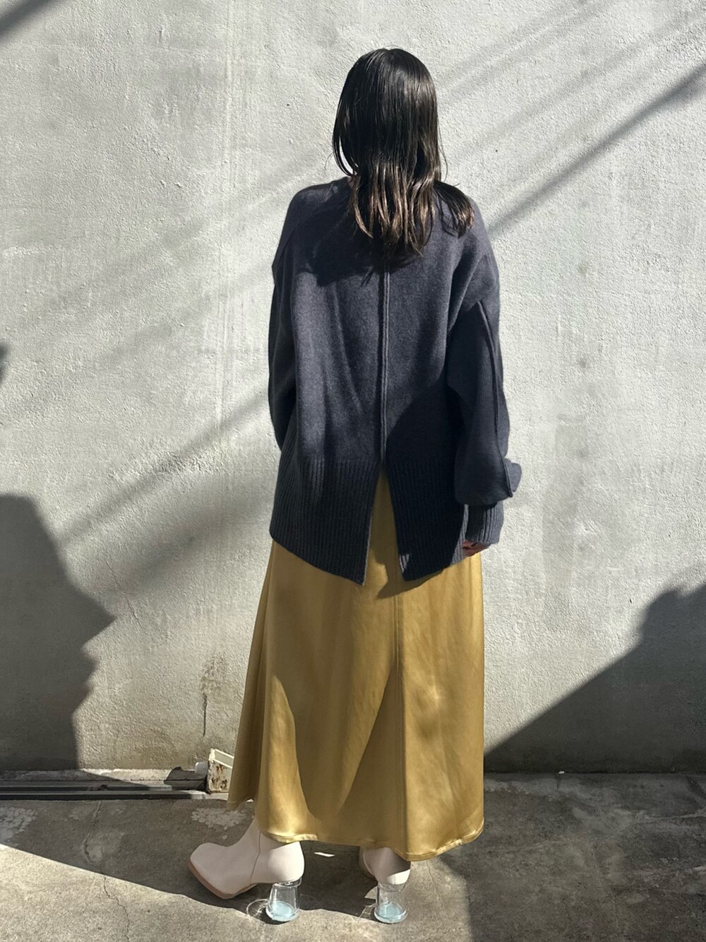 イエロー系のスカート、グレー系のニット/セーター、グレー系のテーラードジャケットを着用したレディースの秋コーディネートの5枚目の写真