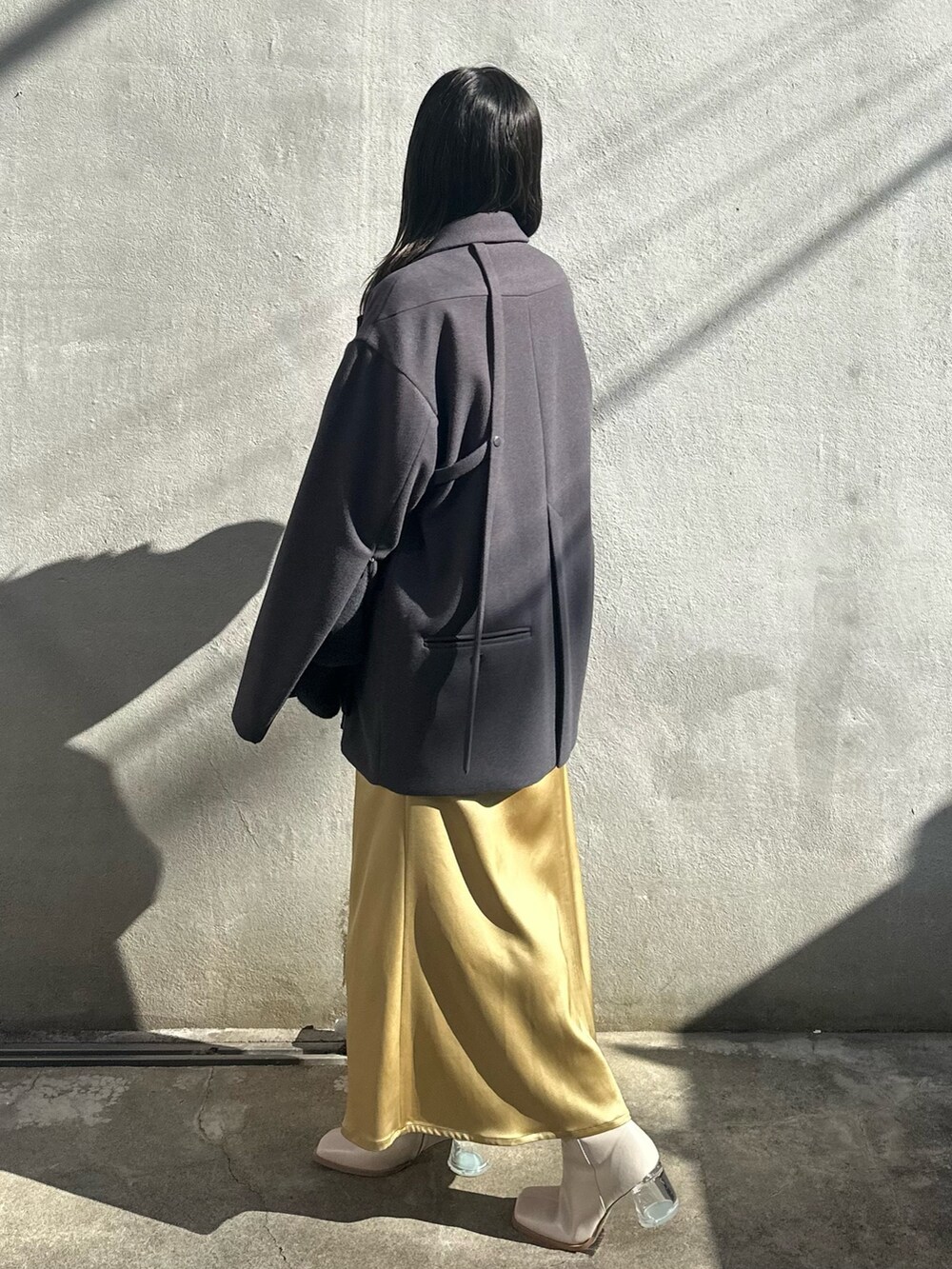 イエロー系のスカート、グレー系のニット/セーター、グレー系のテーラードジャケットを着用したレディースの秋コーディネートの2枚目の写真