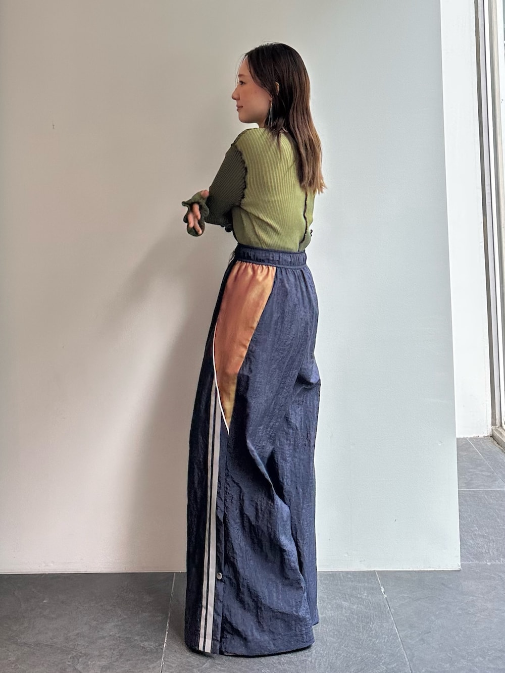 グリーン系のニット/セーター、ブルー系のその他パンツを着用したレディースの秋コーディネートの3枚目の写真