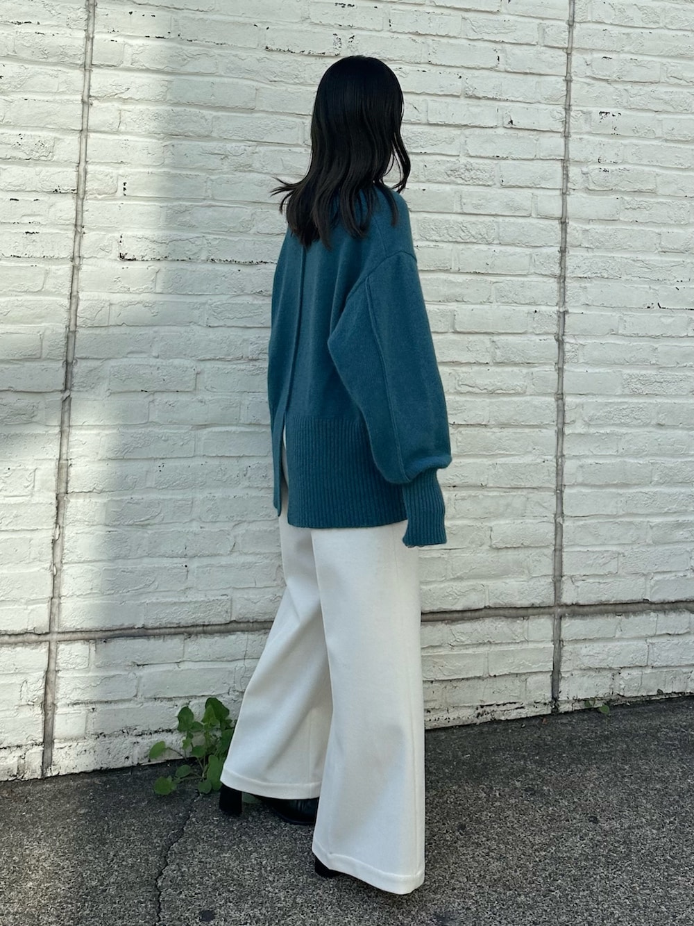 ベージュ系のスラックス、ブルー系のニット/セーターを着用したレディースの秋コーディネートの5枚目の写真