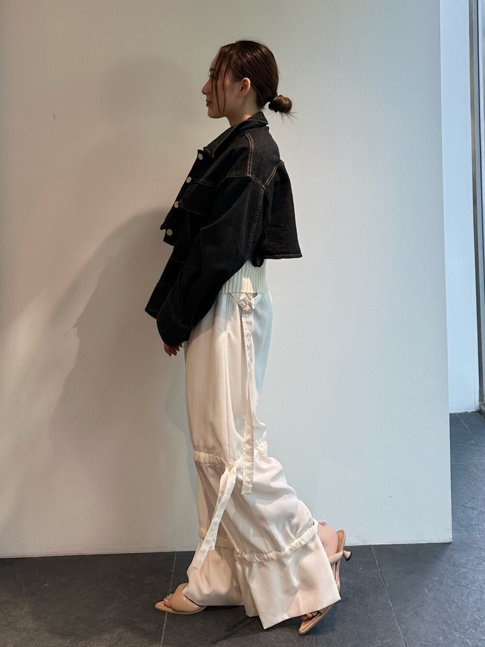 ホワイト系のニット/セーター、ブラック系のデニムジャケット、ホワイト系のその他パンツを着用したレディースの夏コーディネートの4枚目の写真