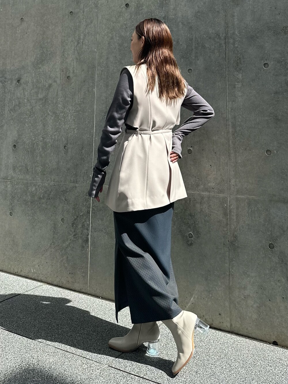 グレー系のTシャツ/カットソー、ブルー系のスカート、ベージュ系のノーカラージャケットを着用したレディースの秋コーディネートの2枚目の写真