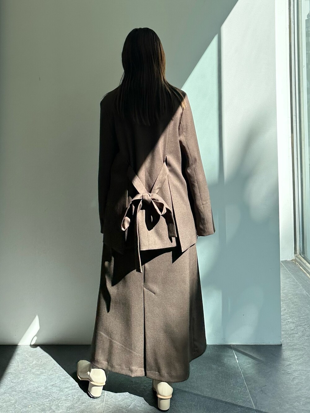 ブラウン系のテーラードジャケット、ブラウン系のスカートを着用したレディースの秋コーディネートの4枚目の写真