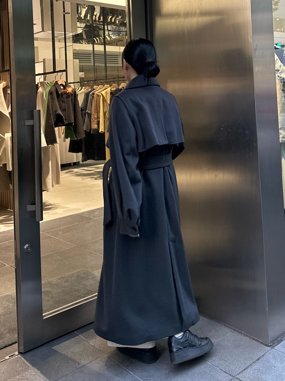 グレー系のステンカラーコートを着用したレディースの秋コーディネートの3枚目の写真