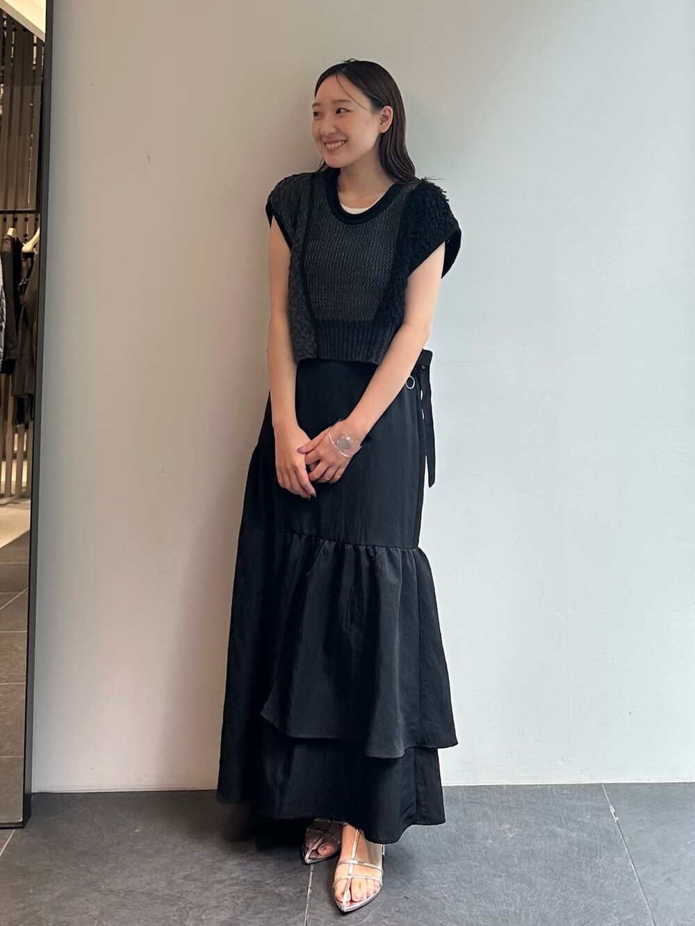 ブラック系のスカート、ブラウン系のベストを着用したレディースの秋コーディネートの2枚目の写真