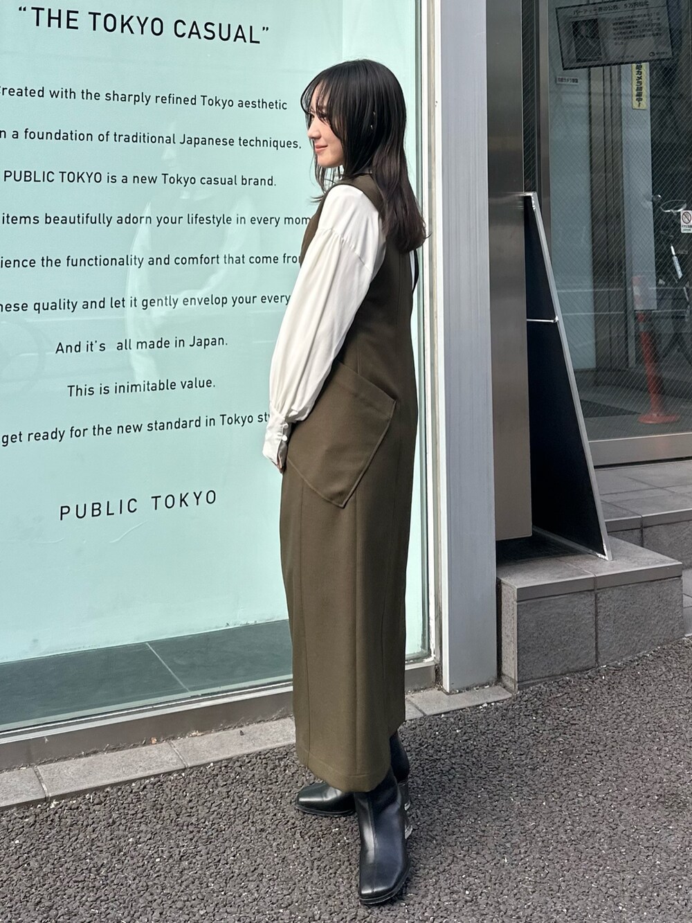 グリーン系のジャンパースカート、ホワイト系のシャツ/ブラウスを着用したレディースの冬コーディネートの2枚目の写真