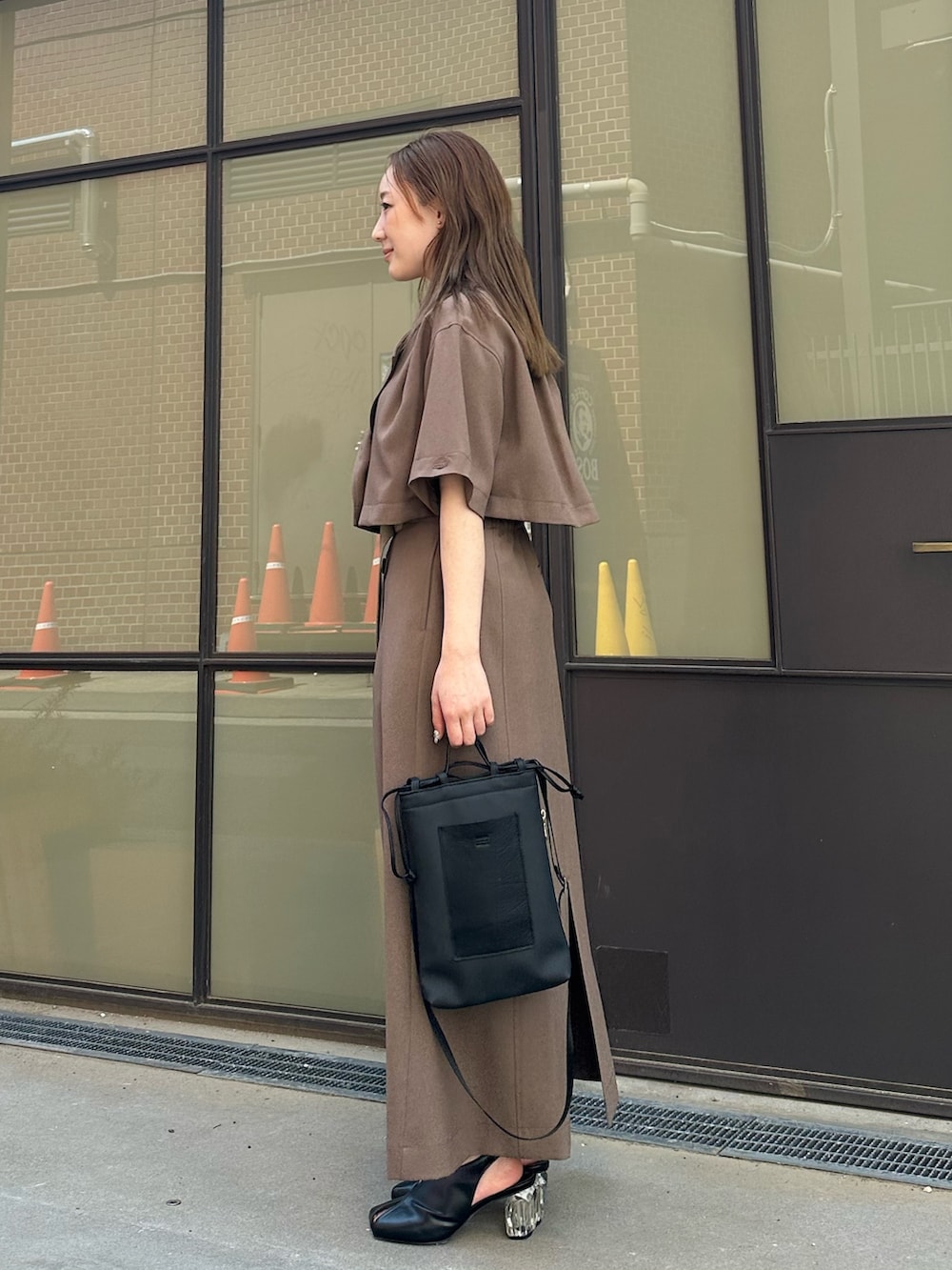 ベージュ系のシャツ/ブラウス、ベージュ系のスカート、ブラック系のハンドバッグを着用したレディースの春コーディネートの3枚目の写真