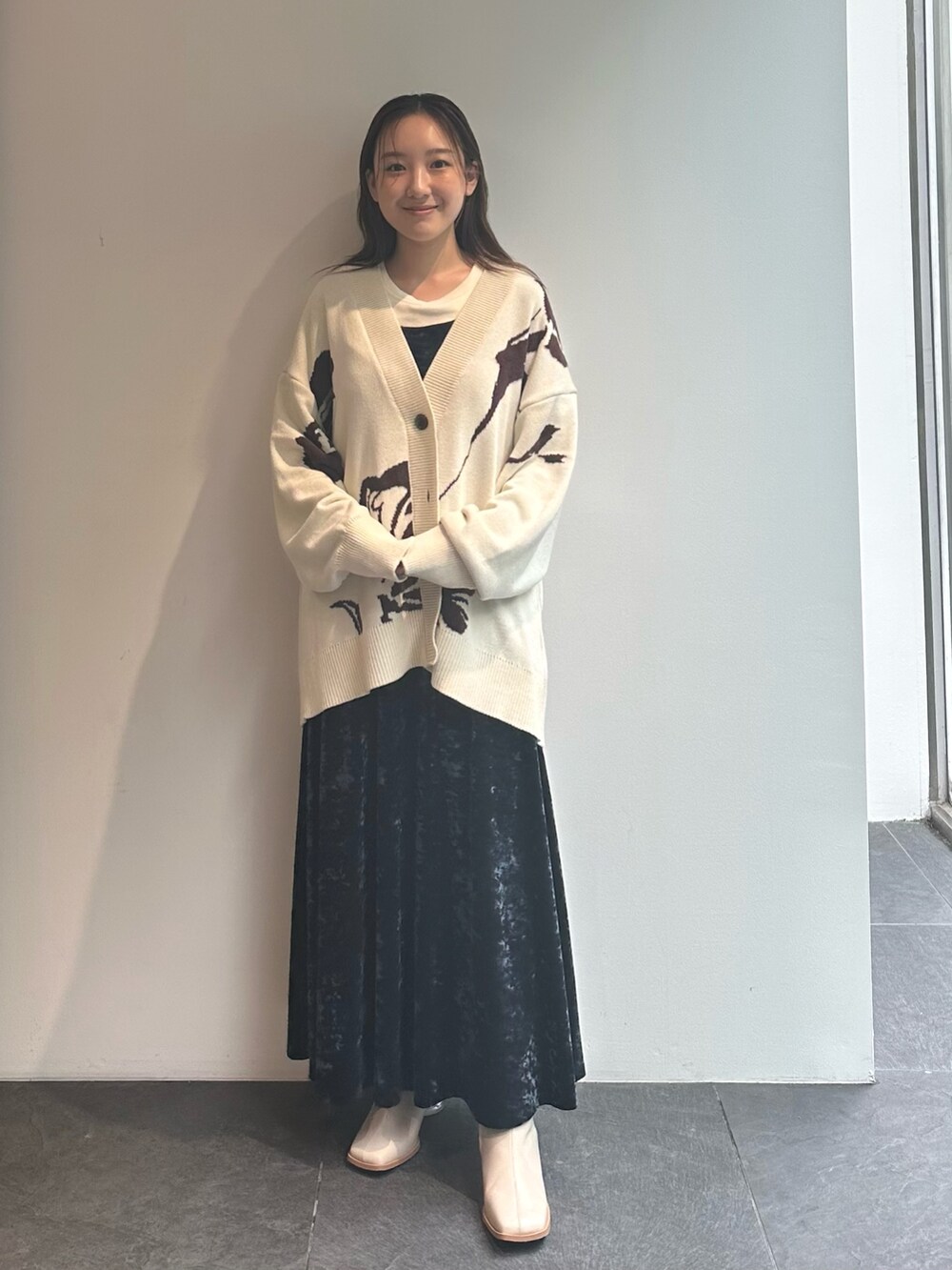 ブルー系のワンピース、ベージュ系のカーディガン/ボレロを着用したレディースの秋コーディネートの2枚目の写真