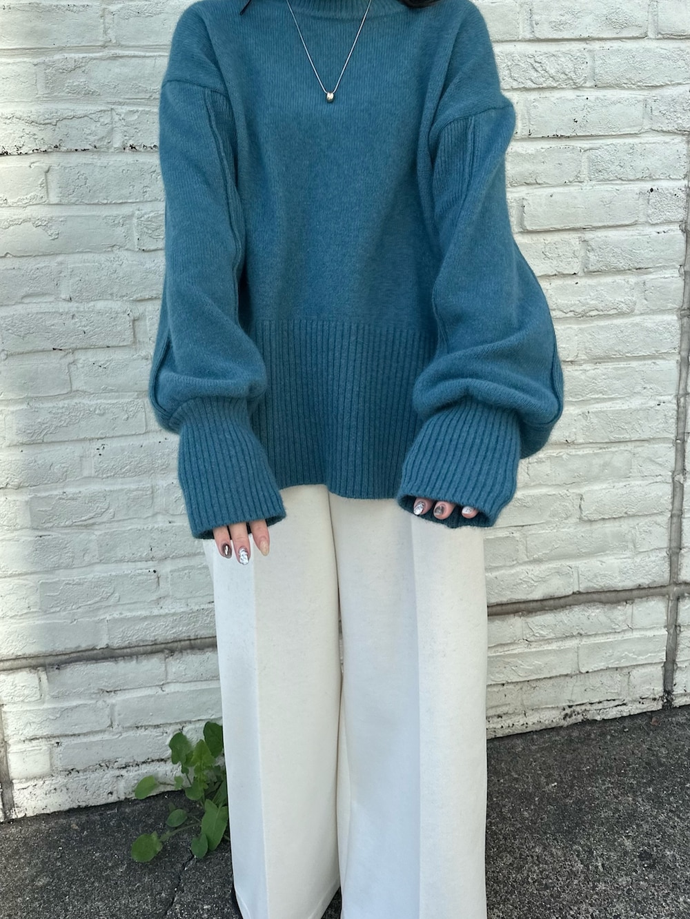 ベージュ系のスラックス、ブルー系のニット/セーターを着用したレディースの秋コーディネートの6枚目の写真