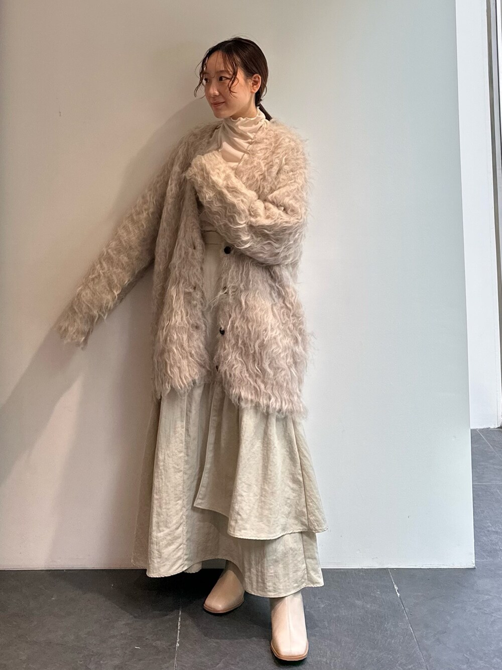 ホワイト系のTシャツ/カットソー、ベージュ系のスカート、ベージュ系のカーディガン/ボレロを着用したレディースの秋コーディネートの2枚目の写真