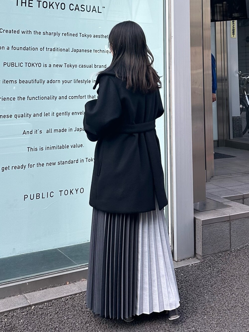 ブラック系のチェスターコート、グレー系のスカートを着用したレディースの冬コーディネートの3枚目の写真