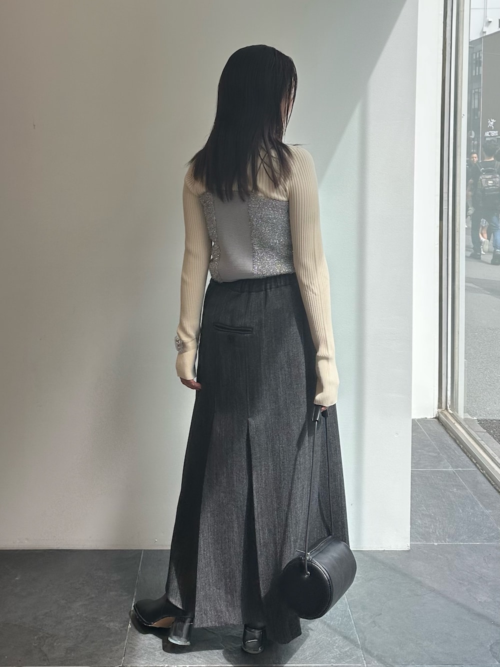 シルバー系のキャミソール、ホワイト系のニット/セーター、グレー系のスカートを着用したレディースの秋コーディネートの3枚目の写真