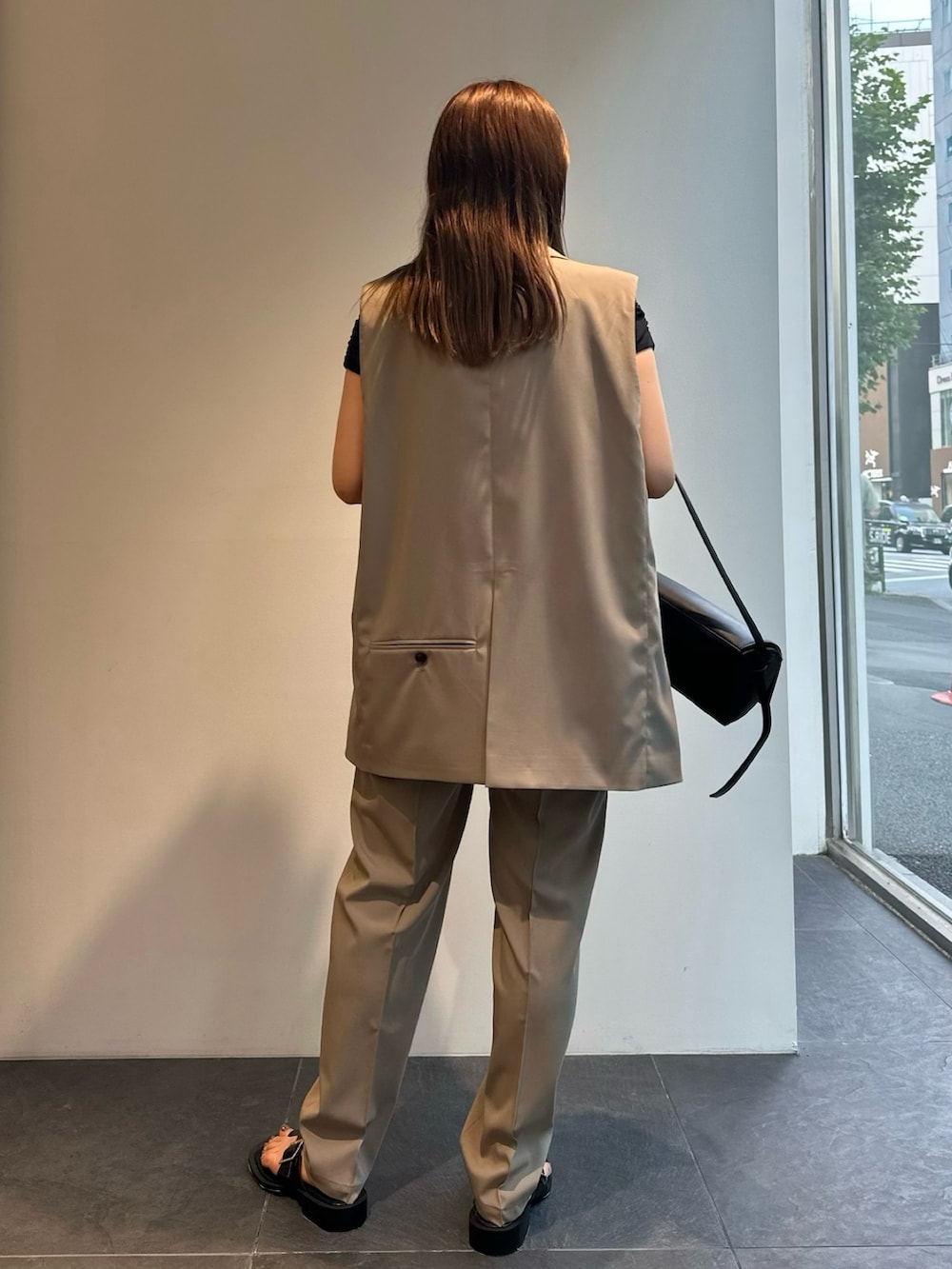グレー系のベスト、グレー系のスラックス、ブラック系のTシャツ/カットソーを着用したレディースの夏コーディネートの4枚目の写真