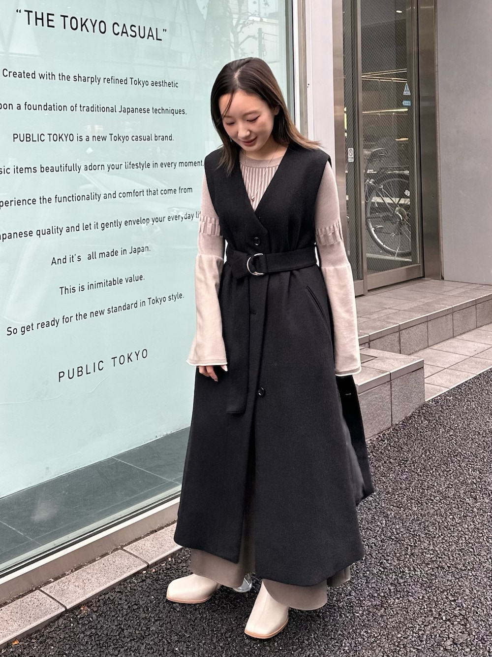 グレー系のワンピース、ブラック系のステンカラーコートを着用したレディースの秋コーディネートの5枚目の写真
