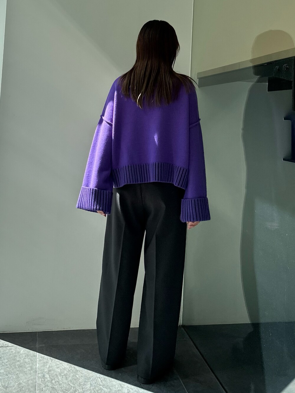 パープル系のニット/セーター、グレー系のスラックスを着用したレディースの秋コーディネートの5枚目の写真