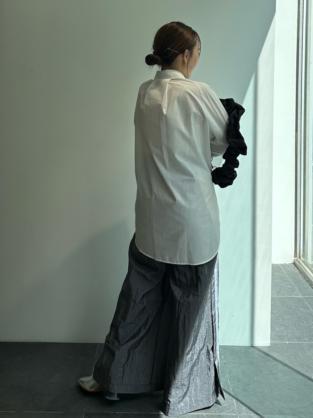 ブラック系のショルダーバッグ、ホワイト系のシャツ/ブラウス、グレー系のその他パンツを着用したレディースの秋コーディネートの5枚目の写真