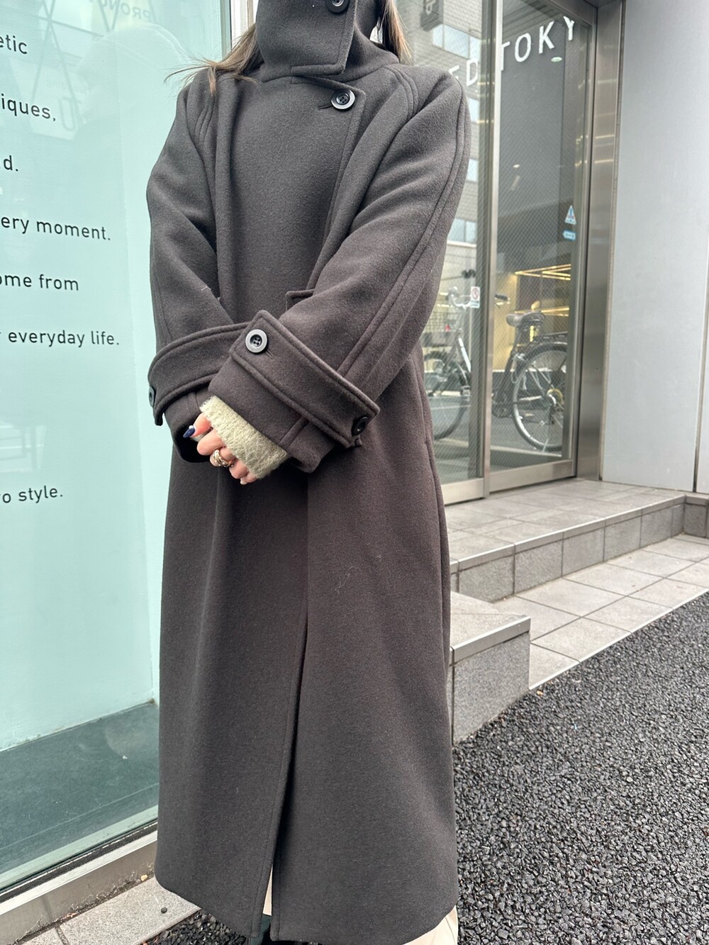 グレー系のステンカラーコートを着用したレディースの秋コーディネートの6枚目の写真