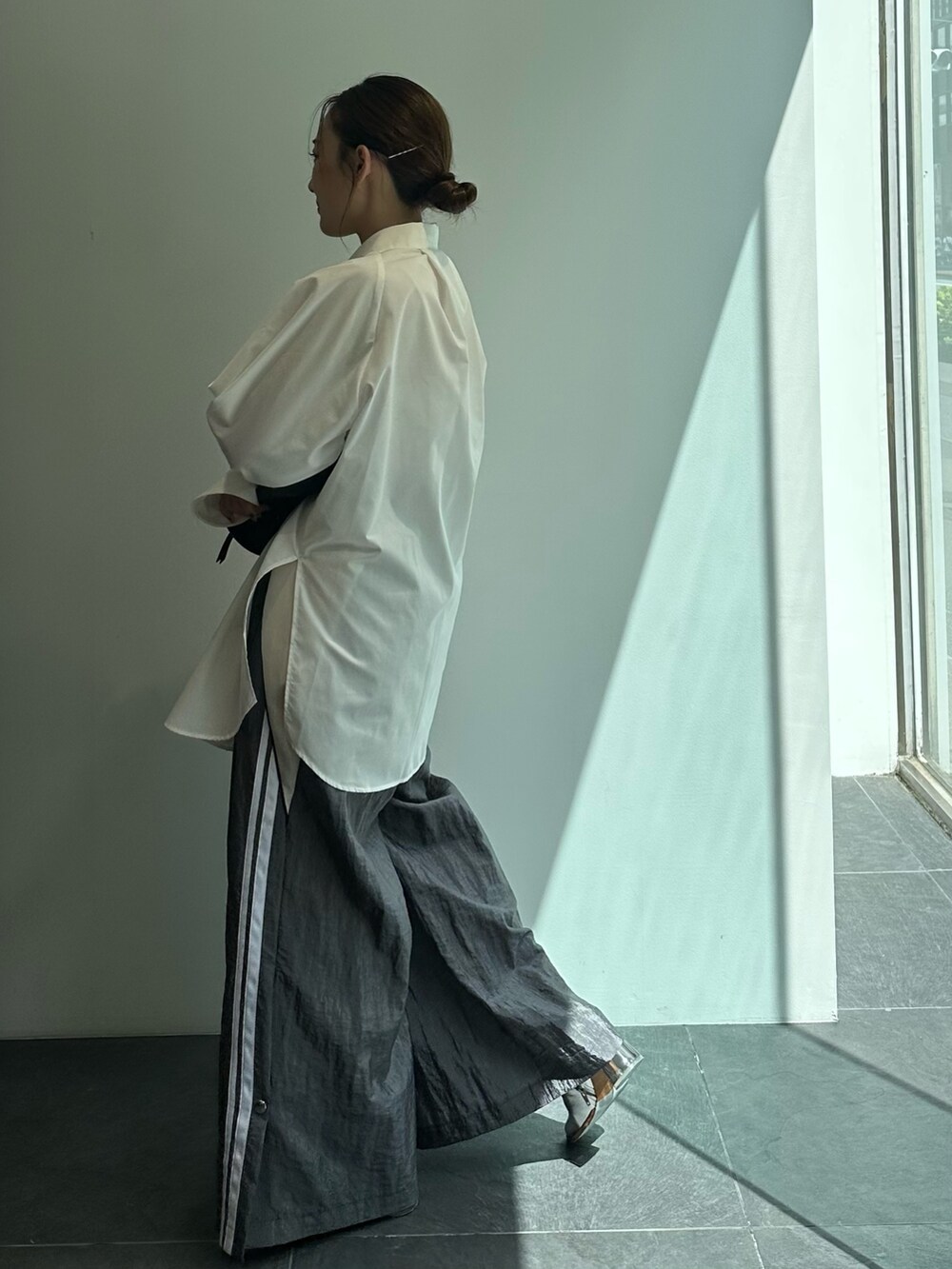 ブラック系のショルダーバッグ、ホワイト系のシャツ/ブラウス、グレー系のその他パンツを着用したレディースの秋コーディネートの3枚目の写真