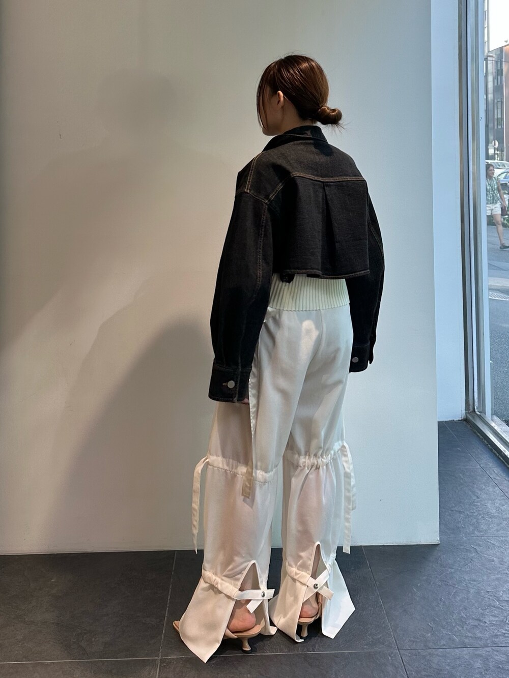 ホワイト系のニット/セーター、ブラック系のデニムジャケット、ホワイト系のその他パンツを着用したレディースの夏コーディネートの5枚目の写真