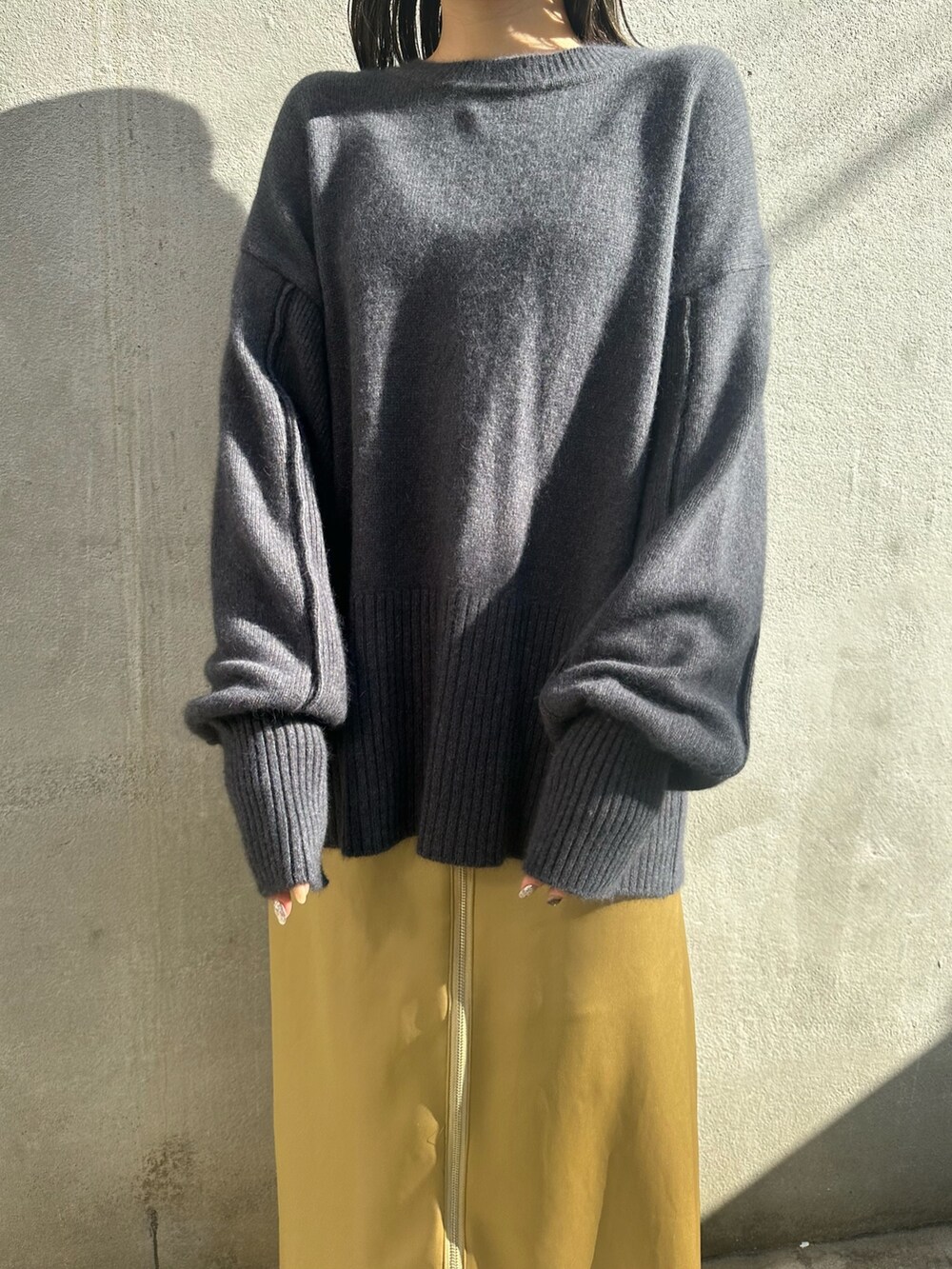 イエロー系のスカート、グレー系のニット/セーター、グレー系のテーラードジャケットを着用したレディースの秋コーディネートの6枚目の写真