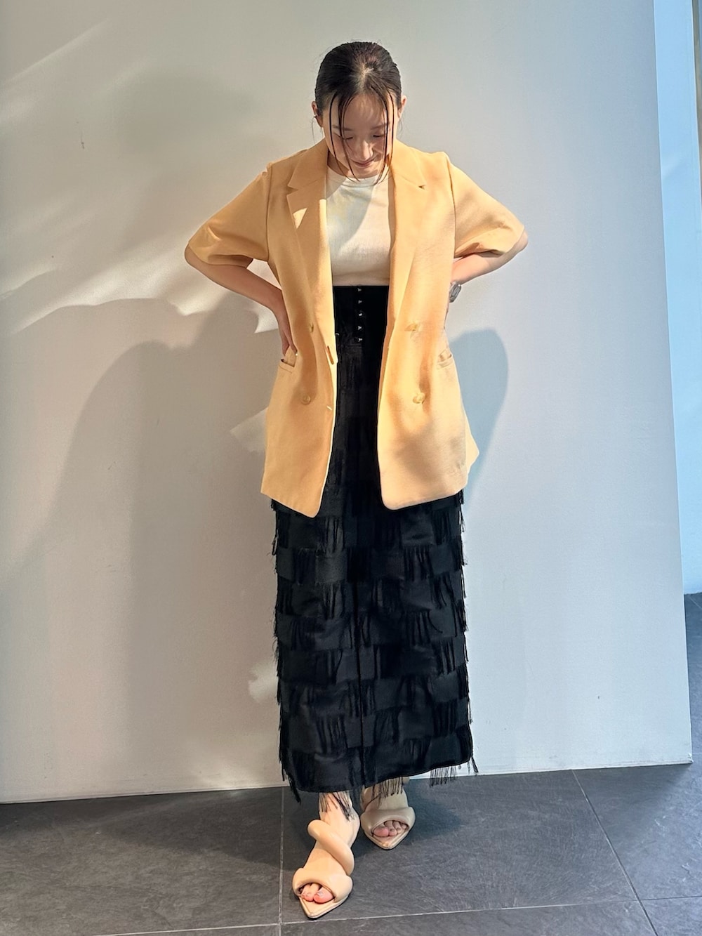 オレンジ系のシャツ/ブラウス、ブラック系のスカートを着用したレディースの夏コーディネートの2枚目の写真