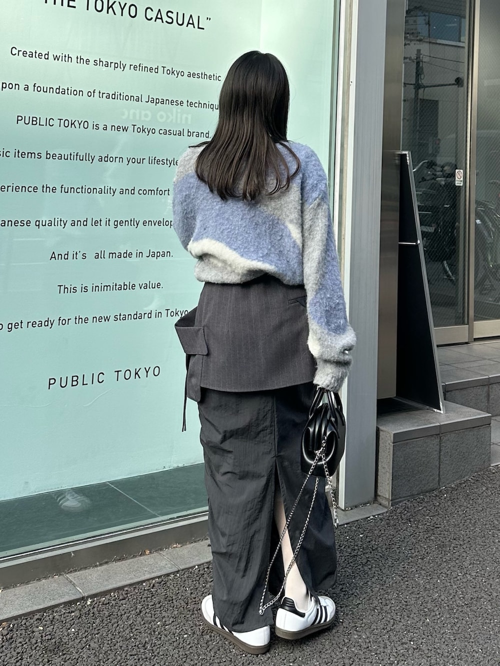 グレー系のスカート、グレー系のニット/セーター、ブラック系のハンドバッグを着用したレディースの冬コーディネートの4枚目の写真