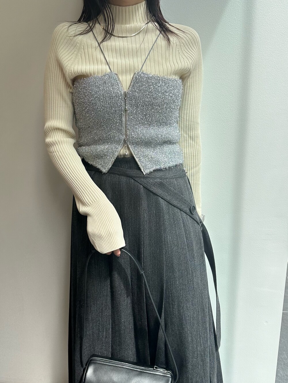 シルバー系のキャミソール、ホワイト系のニット/セーター、グレー系のスカートを着用したレディースの秋コーディネートの4枚目の写真