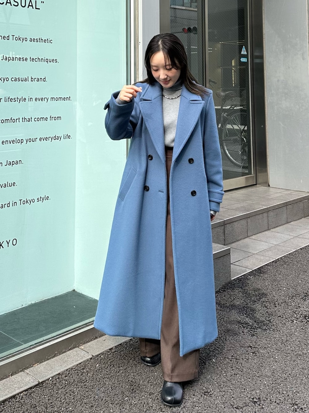 ブルー系のチェスターコートを着用したレディースの秋コーディネートの2枚目の写真