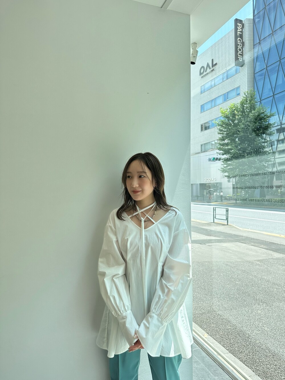 ホワイト系のシャツ/ブラウス、グリーン系のスラックスを着用したレディースの夏コーディネートの6枚目の写真