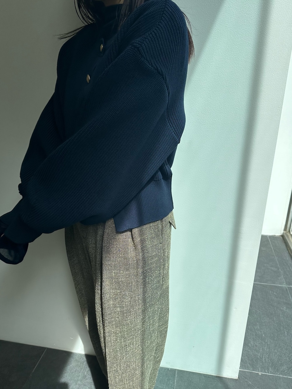 ブラウン系のスラックス、ブルー系のカーディガン/ボレロ、ブルー系のTシャツ/カットソーを着用したレディースの秋コーディネートの5枚目の写真