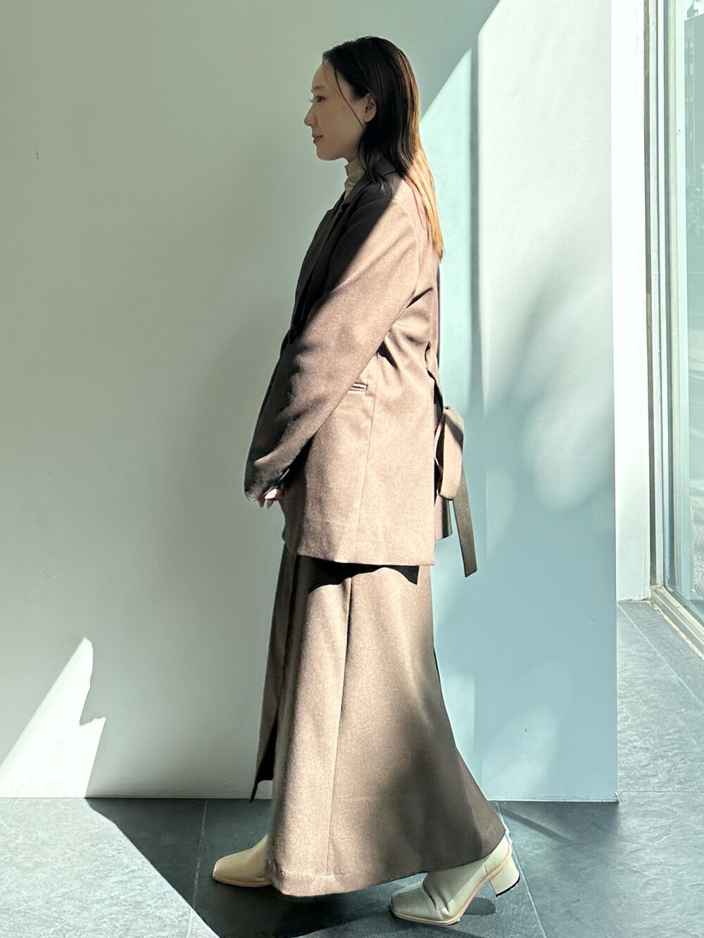 ブラウン系のテーラードジャケット、ブラウン系のスカートを着用したレディースの秋コーディネートの3枚目の写真