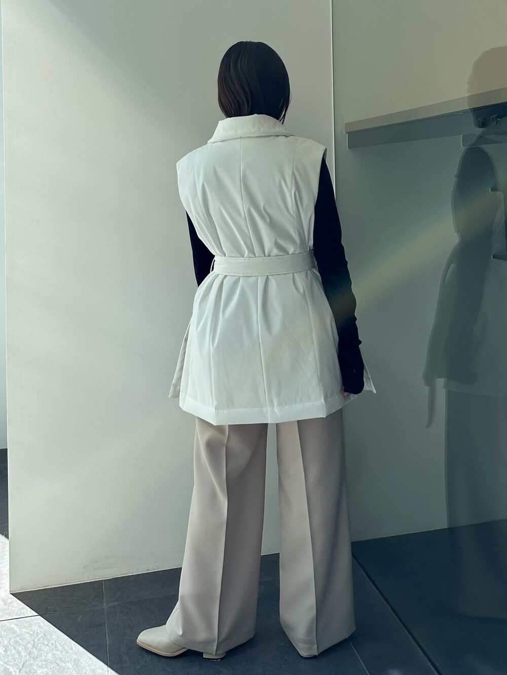 ベージュ系のダウンベスト、ブラック系のTシャツ/カットソー、ベージュ系のその他パンツを着用したレディースの秋コーディネートの5枚目の写真