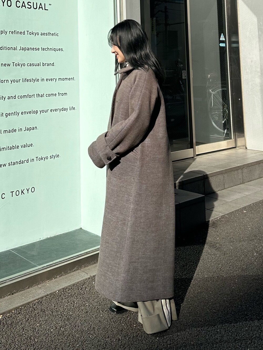 ブルー系のステンカラーコートを着用したレディースの冬コーディネートの2枚目の写真