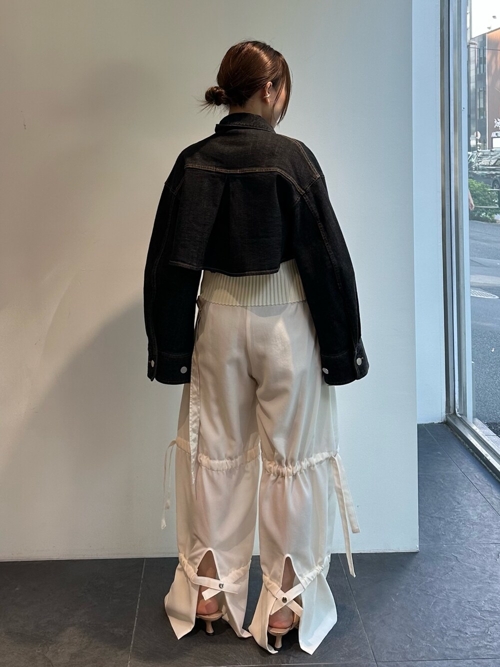 ホワイト系のニット/セーター、ブラック系のデニムジャケット、ホワイト系のその他パンツを着用したレディースの夏コーディネートの6枚目の写真