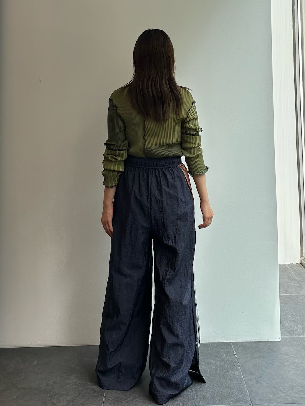 グリーン系のニット/セーター、ブルー系のその他パンツを着用したレディースの秋コーディネートの4枚目の写真