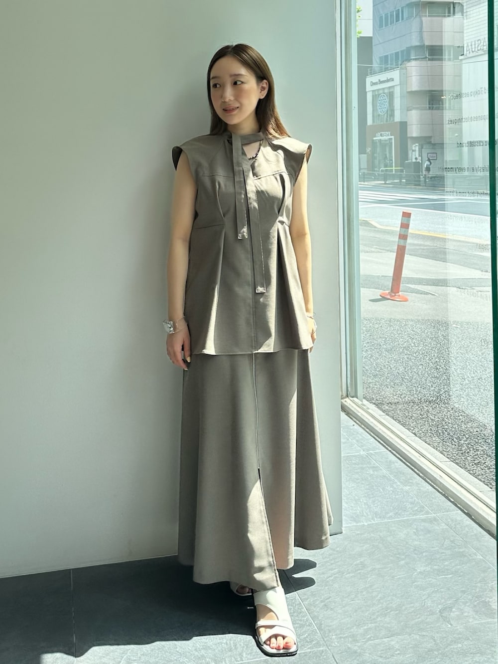 ベージュ系のスカート、ベージュ系のシャツ/ブラウスを着用したレディースの夏コーディネートの3枚目の写真