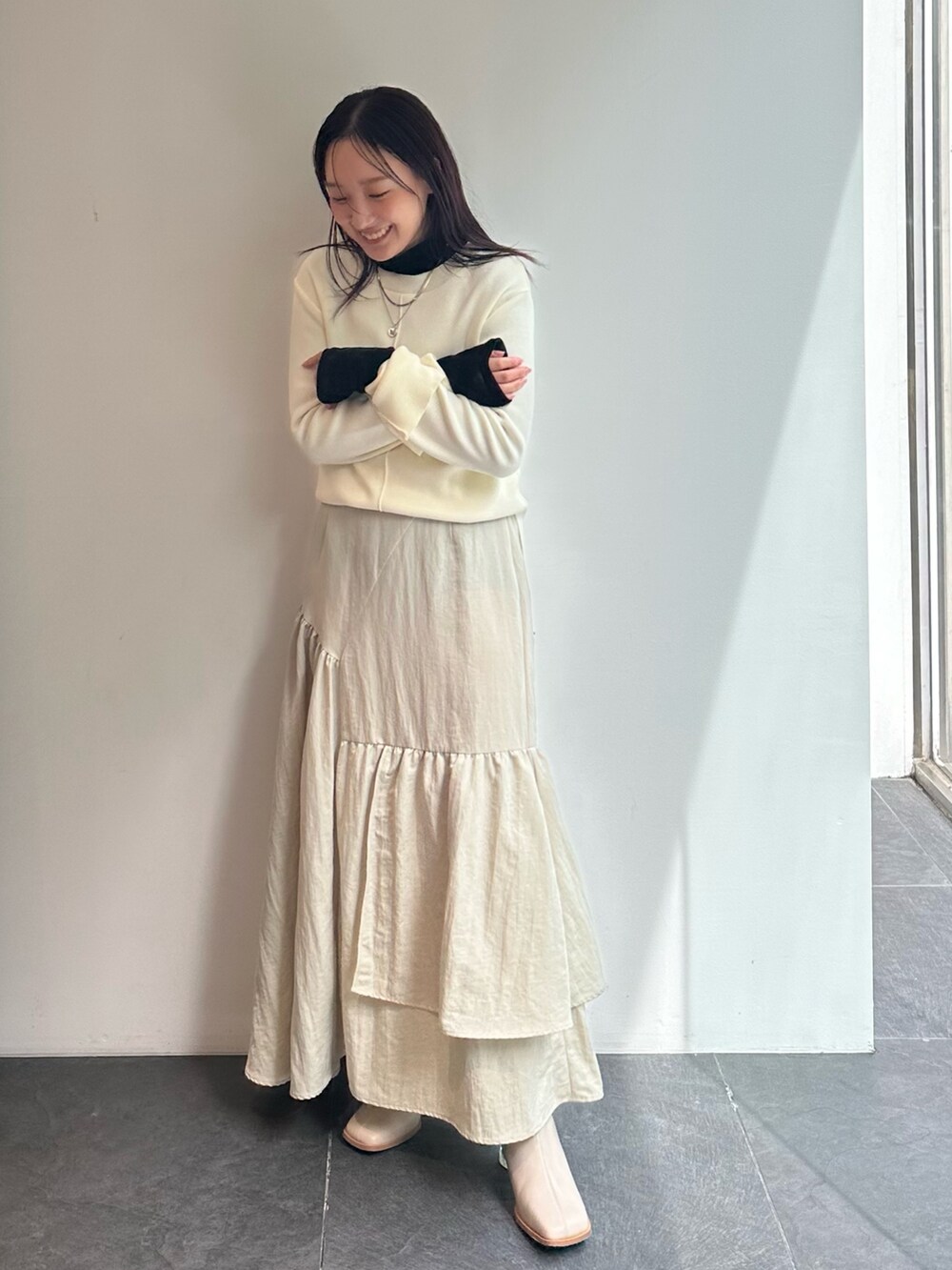 ブラック系のTシャツ/カットソー、ベージュ系のニット/セーター、ベージュ系のスカートを着用したレディースの秋コーディネートの2枚目の写真