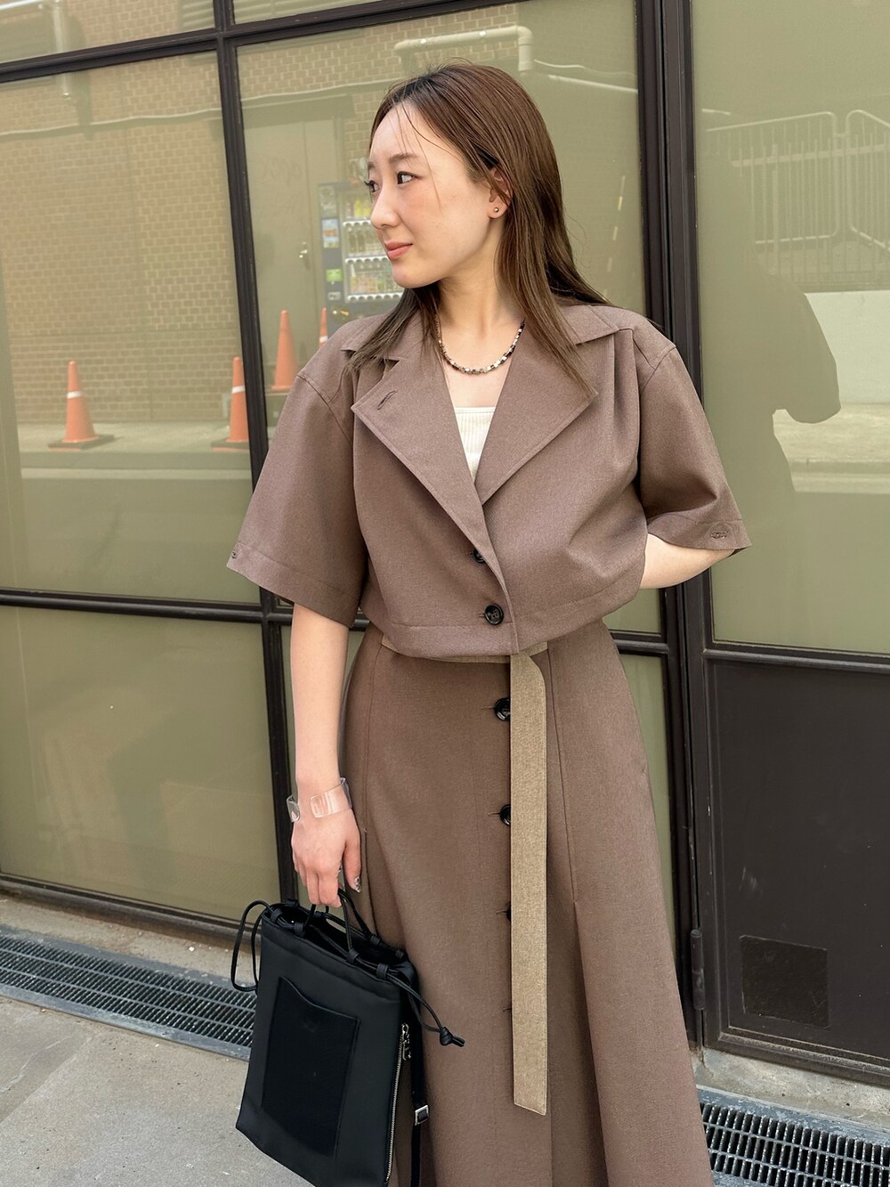 ベージュ系のシャツ/ブラウス、ベージュ系のスカート、ブラック系のハンドバッグを着用したレディースの春コーディネートの7枚目の写真