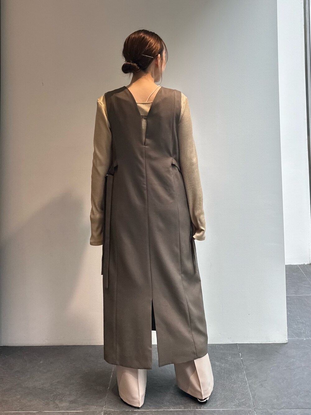 ゴールド系のTシャツ/カットソー、ベージュ系のその他パンツ、グリーン系のワンピースを着用したレディースの秋コーディネートの3枚目の写真