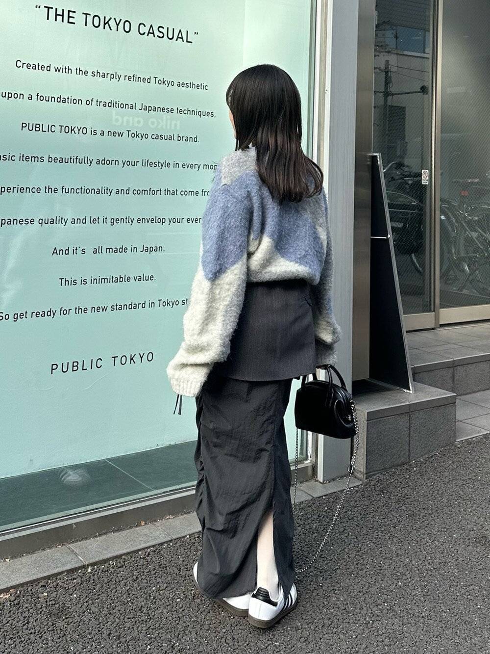 グレー系のスカート、グレー系のニット/セーター、ブラック系のハンドバッグを着用したレディースの冬コーディネートの3枚目の写真