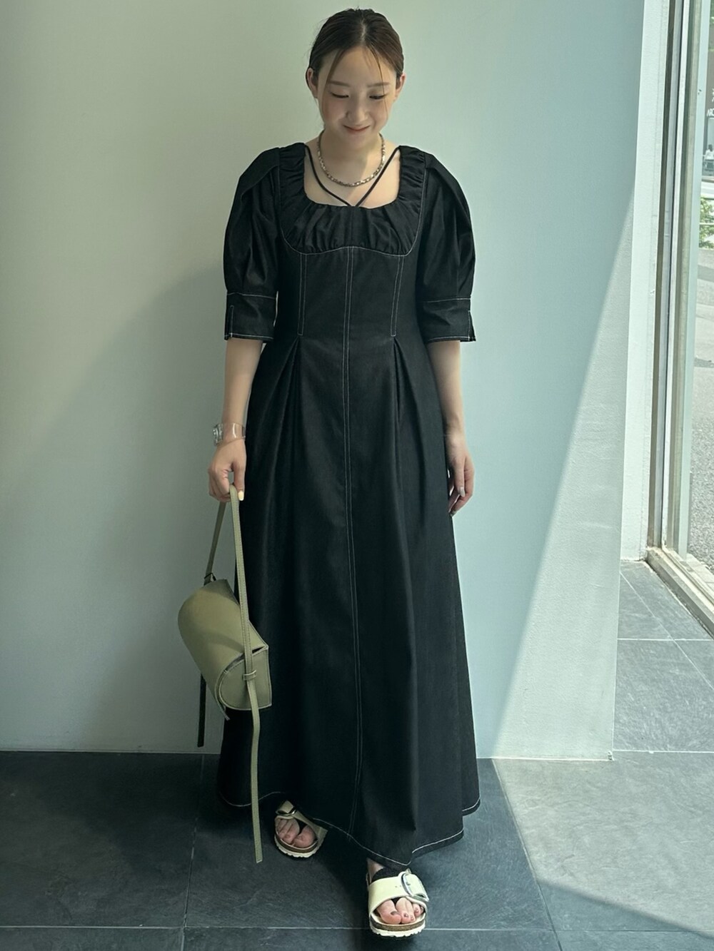 ブラック系のワンピースを着用したレディースの夏コーディネートの3枚目の写真