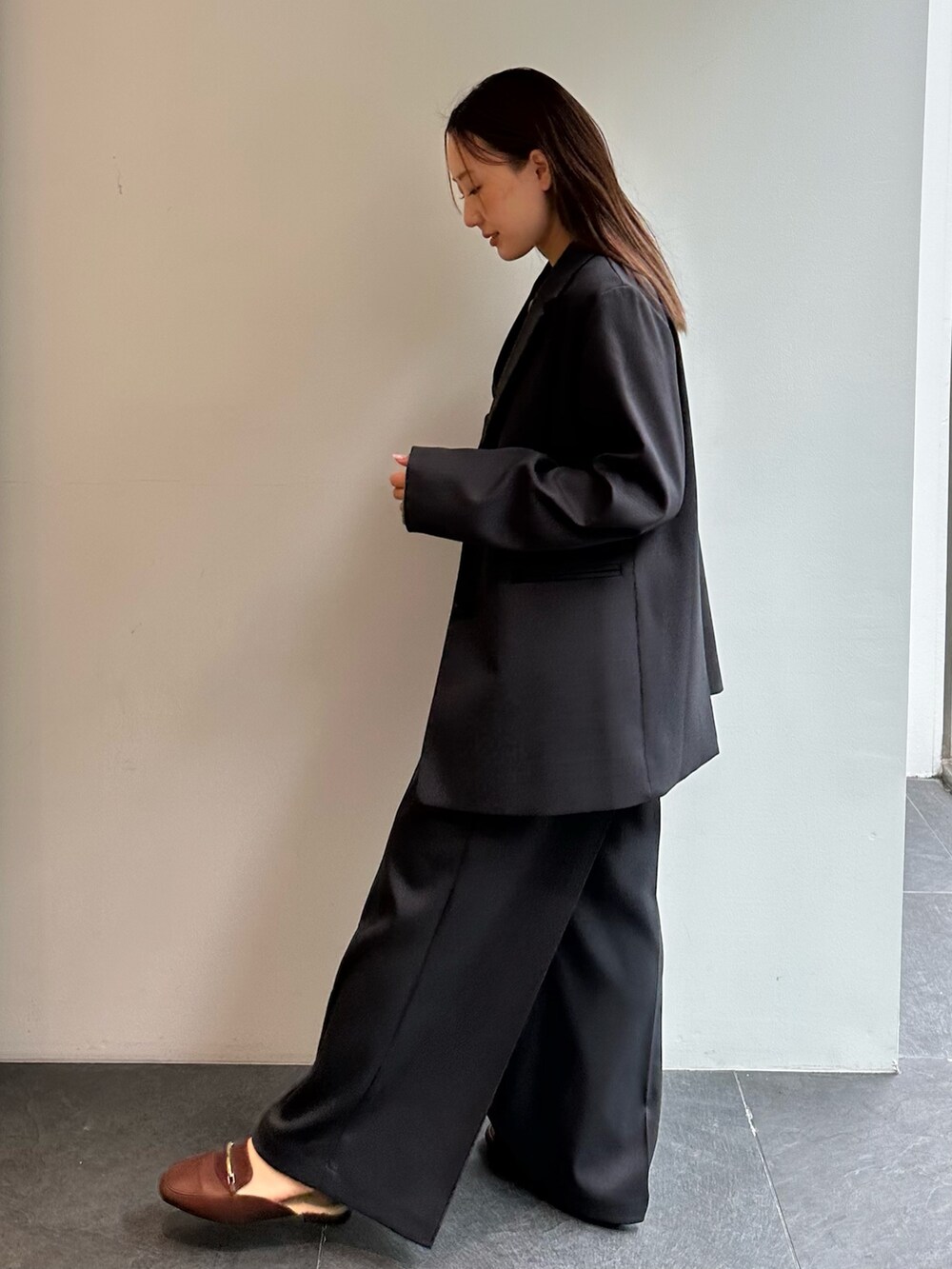 グリーン系のニット/セーター、グレー系のスラックス、グレー系のテーラードジャケットを着用したレディースの秋コーディネートの2枚目の写真