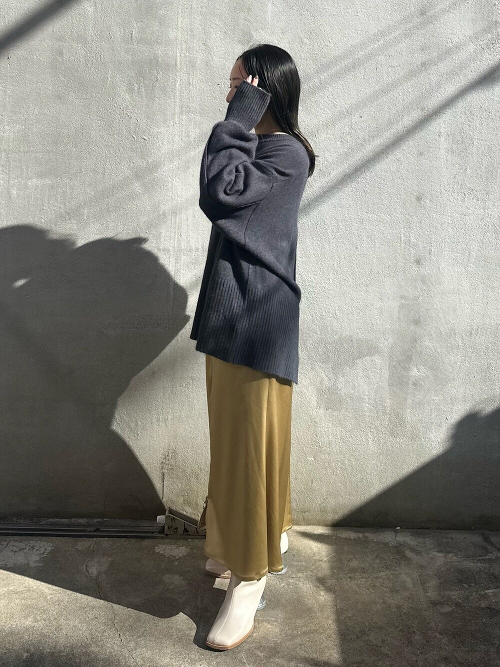 イエロー系のスカート、グレー系のニット/セーター、グレー系のテーラードジャケットを着用したレディースの秋コーディネートの4枚目の写真
