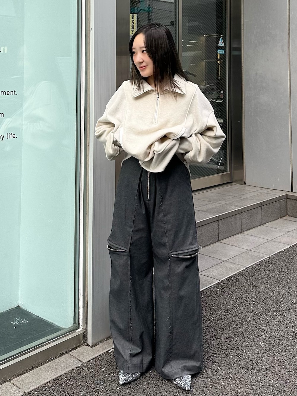 ベージュ系のスウェット、グレー系のスラックスを着用したレディースの秋コーディネートの2枚目の写真