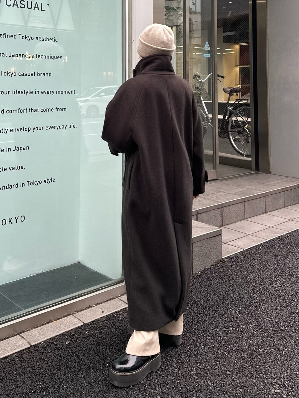 グレー系のステンカラーコートを着用したレディースの秋コーディネートの5枚目の写真