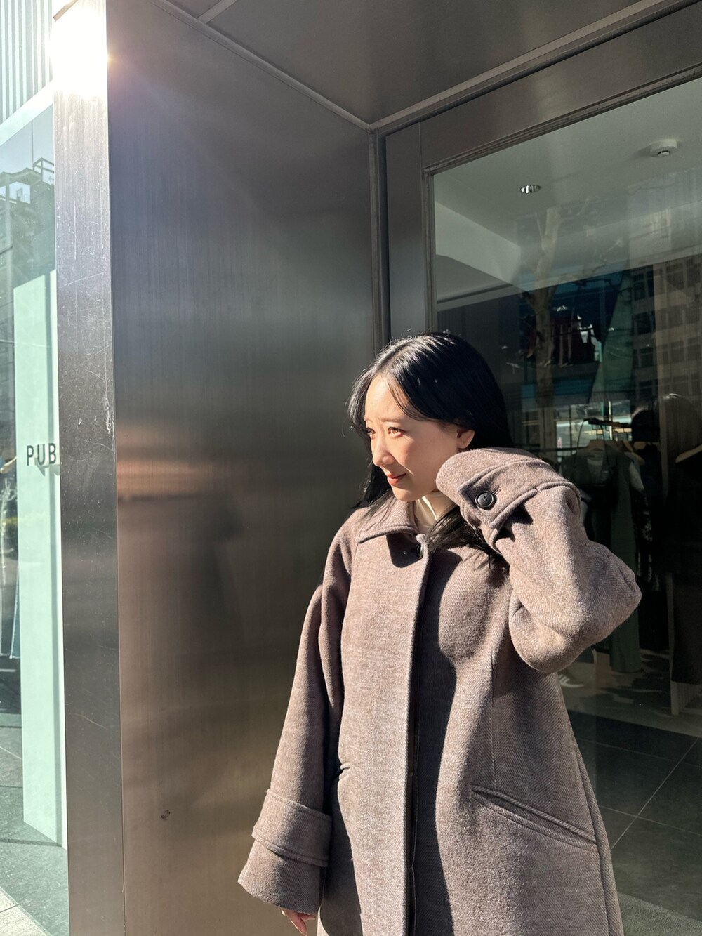 ブルー系のステンカラーコートを着用したレディースの冬コーディネートの5枚目の写真