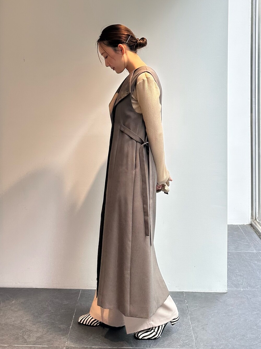 ゴールド系のTシャツ/カットソー、ベージュ系のその他パンツ、グリーン系のワンピースを着用したレディースの秋コーディネートの2枚目の写真