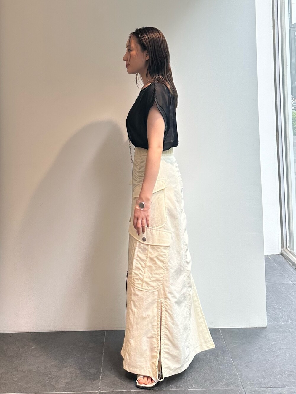 ブラック系のTシャツ/カットソー、ブラック系のベスト、ホワイト系のスカートを着用したレディースの夏コーディネートの6枚目の写真
