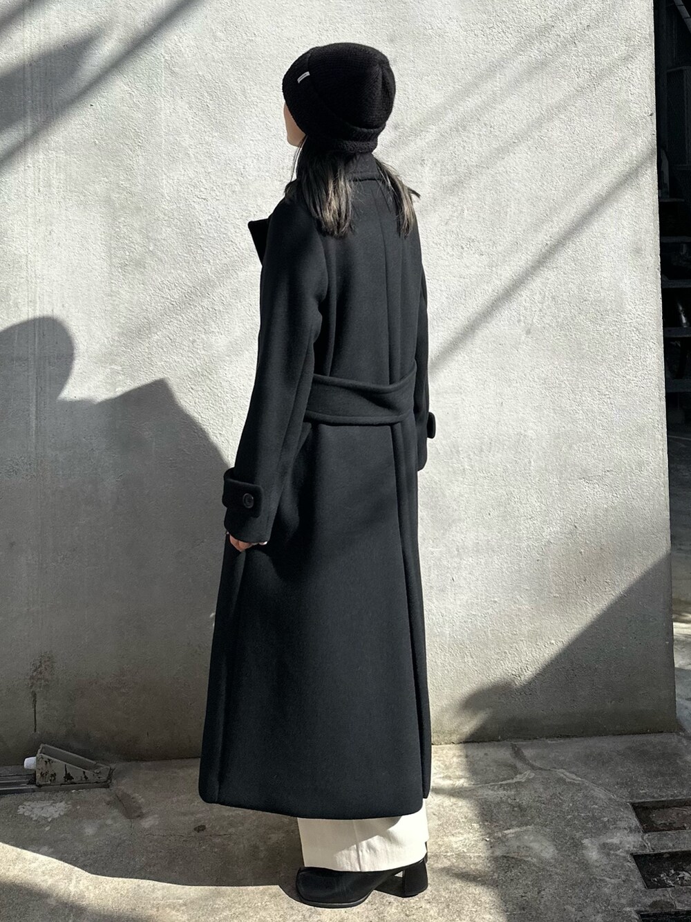 ブラック系のチェスターコートを着用したレディースの秋コーディネートの3枚目の写真